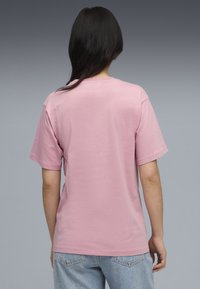 Lyserød bomulds t-shirt med korte ærmer, rund halsudskæring og en afslappet pasform. Ingen synlige designs eller detaljer på ryggen.