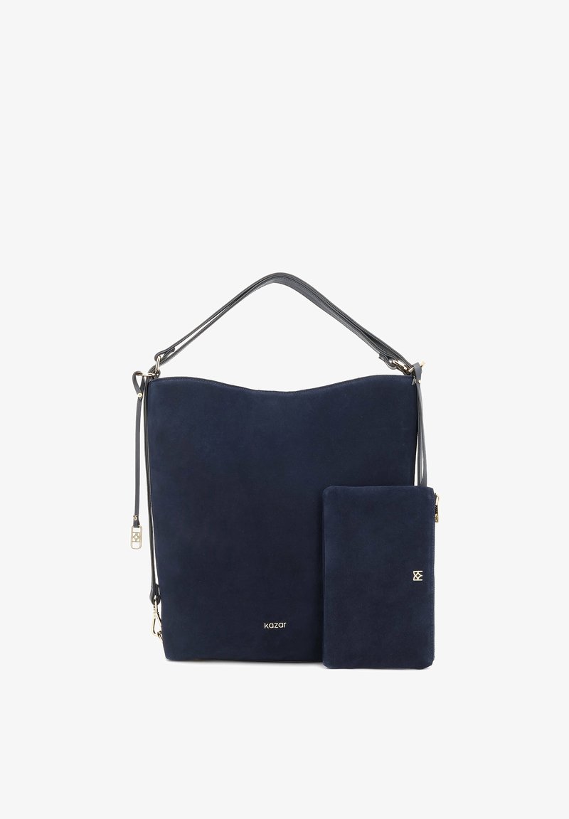 Sac à bandoulière en daim bleu foncé avec pochette rectangulaire assortie, garnitures dorées et sangle noire réglable sur fond blanc.