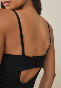 Zwarte bodysuit met dunne schouderbandjes, een haak-en-oog sluiting aan de achterkant en een open rugontwerp. Gladde textuur met een aansluitende pasvorm.