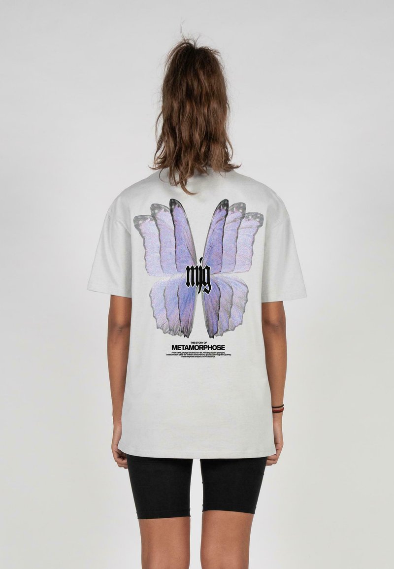 Grå kortærmet t-shirt med et stort lilla sommerfugl grafik på ryggen, med sort tekst nedenfor og en afslappet pasform.
