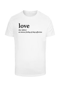 T-shirt blanche présentant le mot "amour" en gras, avec une traduction latine et une définition imprimées en dessous dans une police plus petite.
