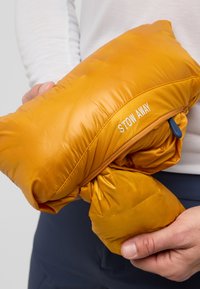 Pochette isolée jaune avec une fermeture éclair, soigneusement rangée. Avec le texte "STOW AWAY", texture douce et design plissé pour la portabilité.