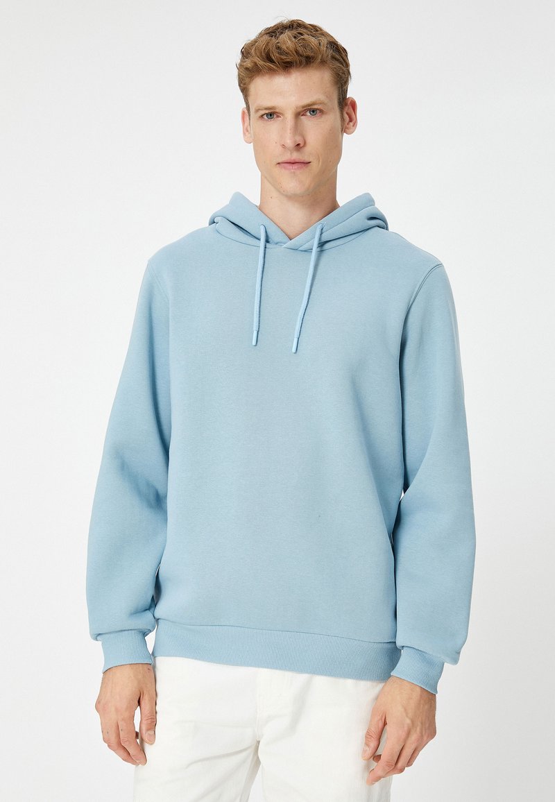 Sudadera de color azul claro hecha de tela suave, con capucha ajustable, puños acanalados y un diseño de corte relajado.