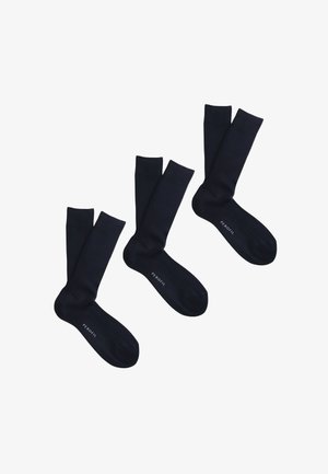 Tre paia di calzini neri a coste con la scritta "PEROFIL" stampata vicino alla punta, disposti diagonalmente su uno sfondo bianco.