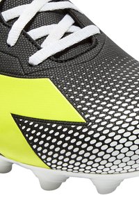 Scarpa da calcio nera e gialla con tomaia in rete testurizzata, lacci bianchi e un distintivo logo giallo. Presenta motivi a punti e tacchetti sagomati.