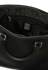 Čierna kožená kabelka so striebornými kovovými detailami, hladká textúra a vnútorná vrecko so zipsom. Podšité čiernou látkou s jemným vzorom loga.