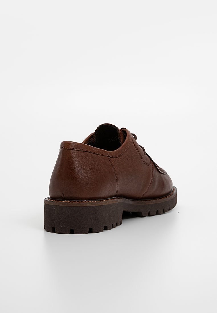 Scarpa in pelle marrone con forma arrotondata, superficie testurizzata e suola spessa e robusta. Presenta dettagli minimi e una costruzione solida.