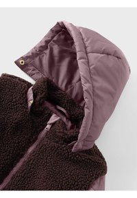 Braune Fleece-Weste mit einer rosa satingefütterten Kapuze. Verfügt über einen Frontreißverschluss, einen plüschigen Stoff und goldene Hardware-Details.