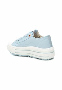 Zapatilla de lona azul claro con una suela blanca gruesa, que presenta punta redonda, parte delantera con cordones y acentos naranjas en los ojales y el talón.