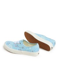 Blå kanvas sneakers med ett blommönster, vita snören och en gummisula med vaffelmönster. Varumärkeslogotyp finns på sidan.