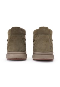 Botas de tobillo de ante verde oliva con un diseño liso, tacón redondeado y superficie ligeramente texturizada. Presenta una marca minimalista en la parte trasera.