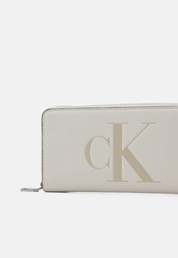 Calvin Klein Jeans SCULPTED ZIP AROUND MONO - Portafoglio - eggshell