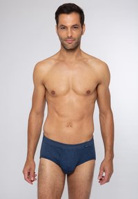 Marineblauwe herenslip met gestreept patroon, elastische tailleband en een klein merklabel aan de linkervoorzijde. Het materiaal lijkt zacht en rekbaar te zijn.