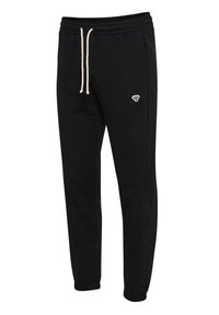 Sorte tapered joggingbukser med elastisk linning, hvide snører, sidelommer og et lille hvidt broderet logo på højre lår.
