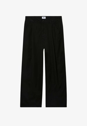 Pantaloni neri a gamba larga con tasche laterali, passanti per cintura, chiusura con bottone ed etichetta bianca visibile con la scritta "OBEY" in vita.