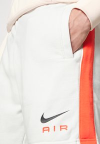 Nike Sportswear AIR - Tracksuit bottoms - summit white/crimson