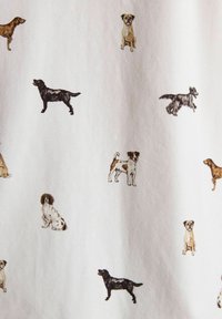 Rôzne ilustrácie malých psov v rôznych pozíciách a farbách roztrúsené na bielom látkovom pozadí.