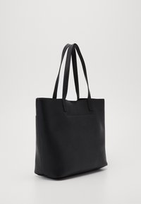 Zwarte totebag met een minimalistisch ontwerp, voorzien van twee stevige handvatten en een gladde, matte textuur. Het zijpaneel toont een subtiele naadtoevoeging.
