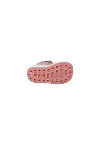Suola di scarpa con una superficie in gomma rosa, caratterizzata da motivi circolari e ovali per una migliore aderenza. Progettata per offrire grip e stabilità, con dettagli minimalisti.