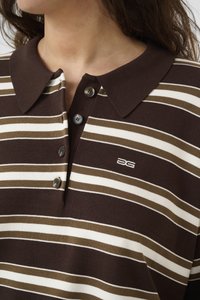 Brown and cream striped polo shirt with a collar, three buttons, and a small embroidered logo on the chest. Soft cotton material.