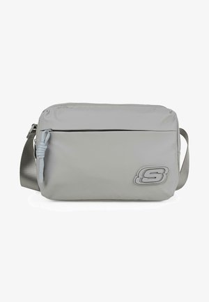 Bolso bandolera gris de nylon, con un bolsillo frontal con cremallera, correa ajustable y un logo prominente en el lateral. Textura suave.