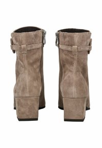 Botas de tobillo de ante marrón con tacones cuadrados, cremallera trasera y detalle de correa decorativa, mostradas desde la parte trasera sobre un fondo blanco.