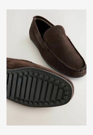 Prunadest nahkpahklid tekstureeritud ülemise osaga, ümarate varvastega ja kummist tallaga, millel on ringikujulised ja triibulised haardemustrid.