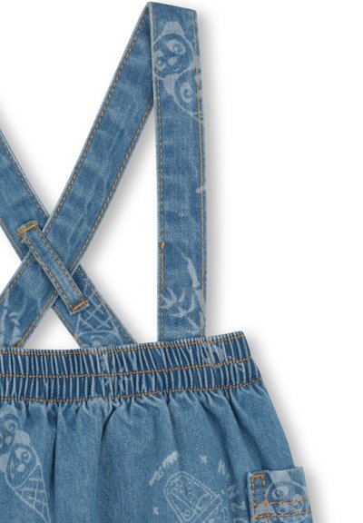 Jeansowe ogrodniczki z paskami skrzyżowanymi na plecach, w kolorze niebieskim, z elastyczną talią i delikatnymi białymi wzorami przedstawiającymi sowy i rożki lodów. Akcenty w postaci pomarańczowych przeszyć.