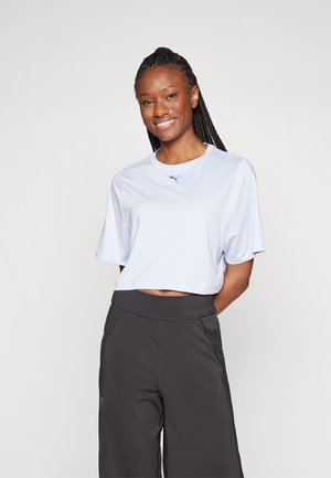 Ljusblå kortärmad t-shirt med korta ärmar, försedd med en liten marinblå logotyp på bröstet, ihop med svarta vida sportbyxor.
