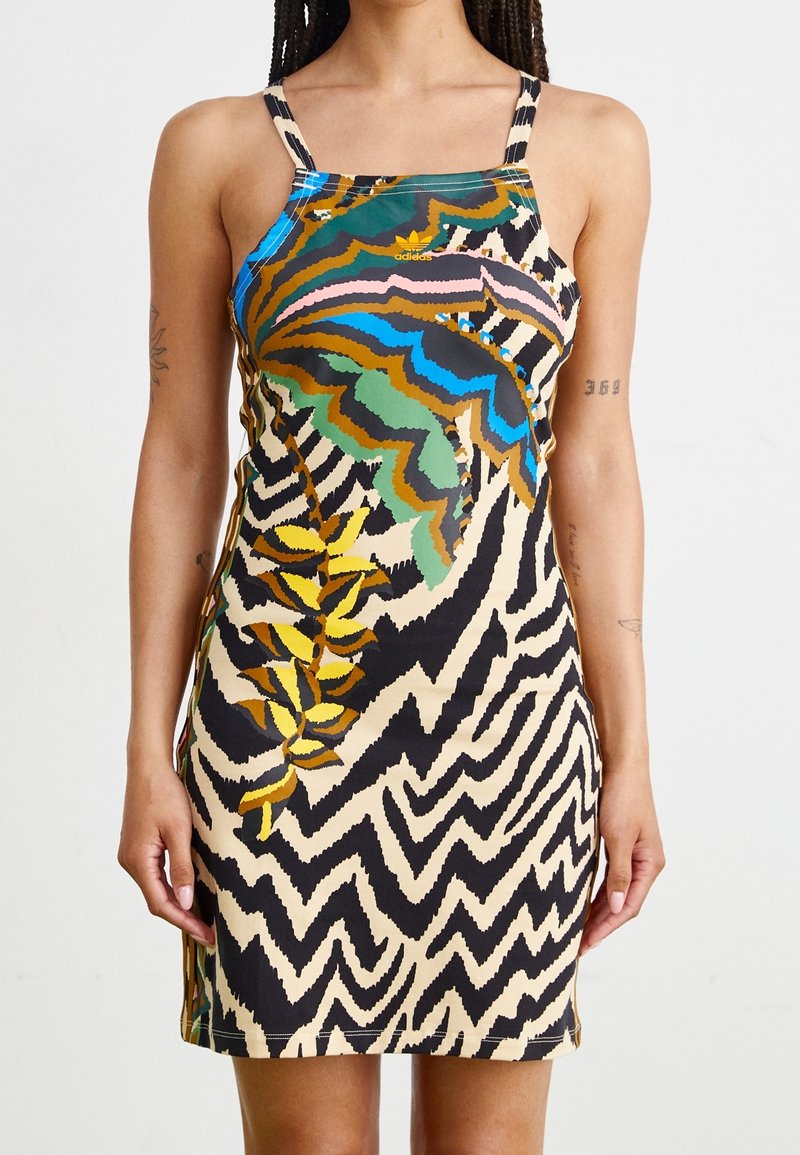 Graphic-patterned sleeveless dress in black, beige, green, and blue. Features zigzag and leaf designs, with a fitted silhouette and spaghetti straps.