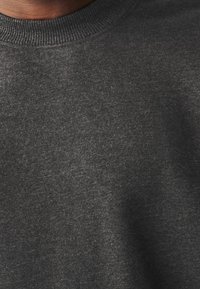 Svetle šedá mikina s žebrovaným kulatým výstřihem, s jemnou texturou a jednoduchým, nezdobeným designem.