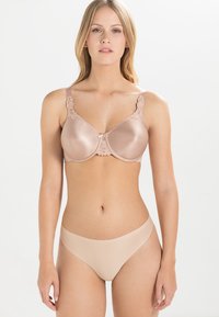 Nude satin bra with floral lace accents, padded cups, and adjustable straps. Paired with matching seamless nude briefs.