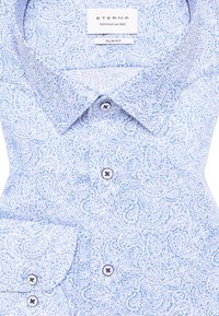 Slim fit shirt in lichtblauw met een paisleypatroon. Beschikt over een button-down kraag, twee knopen op de sluiting en een zachte, gestructureerde stof.