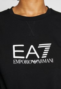Svart sweatshirt i bomull med rund halsringning och vit tryckt logotext "EA7 EMPORIO ARMANI" med distinkta detaljer.