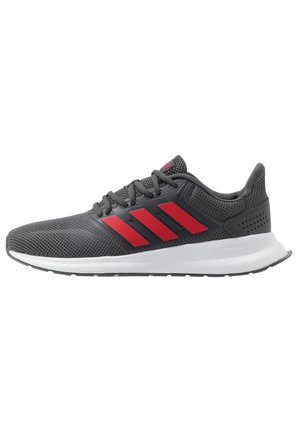 Chaussure de sport gris foncé avec des rayures rouges, des lacets noirs, une semelle blanche et une tige en mesh respirant, vue de côté sur fond blanc.