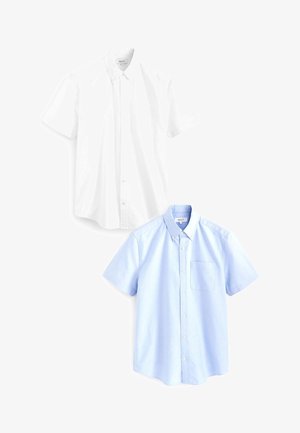 Lyhythihaiset nappikauluspuserot valkoisesta ja vaaleansinisestä puuvillasta; molemmissa on kaulus ja vaaleansinisessä paidassa rintatasku.