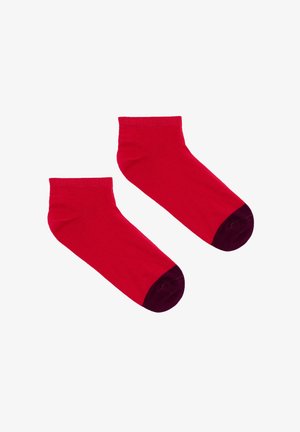 Czerwone skarpetki kostkowe z ciemnofioletowym palcem. Wykonane z gładkiej mieszanki bawełny, z prążkowanym mankietem dla ciasnego dopasowania.