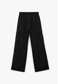 Pantalones cargo negros de corte holgado, con cinturilla elástica, dos bolsillos laterales y una tela texturizada. Presenta bolsillos cargo adicionales en los laterales.