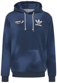 Námořnická modrá mikina s kapucí vyrobená z měkké látky, se klokanní kapsou, bílými šňůrkami a tištěnými logy Adidas na hrudi.