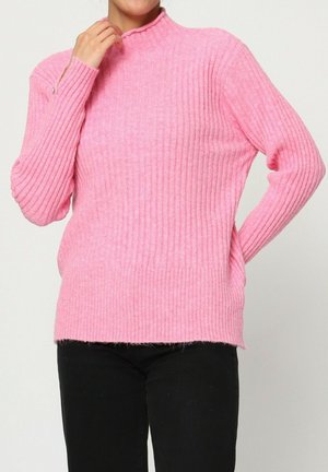 Pull en maille côtelée rose avec un col montant, des manches longues et une coupe décontractée. Il présente un motif texturé et un détail d'ouverture sur les côtés.
