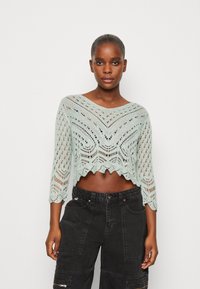 Spitzenbündchen-Pullover in hellem Mint mit gewelltem Saum und drei Viertelärmeln, lockerem Strickmuster und offener Webart.