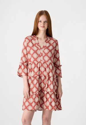 Robe à motifs rouges avec un design en plusieurs niveaux, présentant des manches trois-quarts et un décolleté en V. Le tissu a une texture douce et des motifs floraux.