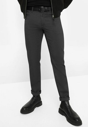 Grijze slim-fit broek van textuurstof, met een opgerolde zoom, gedragen met een zwarte riem en leren enkellaarsjes.