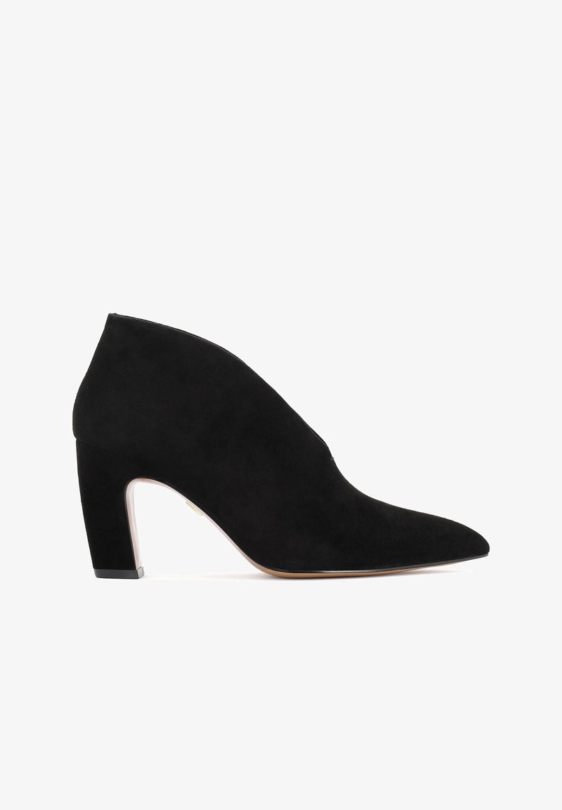 Musta sametist pahkluudega saapad, millel on terav nina, sile tekstuur ja jämedam konts. Erakordne külje lõike detail täiustab disaini.