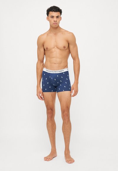 Calzoni boxer blu navy con una fascia elastica bianca, caratterizzati da un motivo a logo ripetuto. Tessuto liscio con una vestibilità aderente.