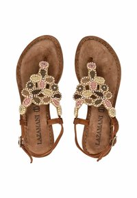 Sandales plates marron avec des bandoulières décoratives perlées en crème, rose et noir. Elles disposent d'une semelle intérieure rembourrée et d'une fermeture à boucle réglable.