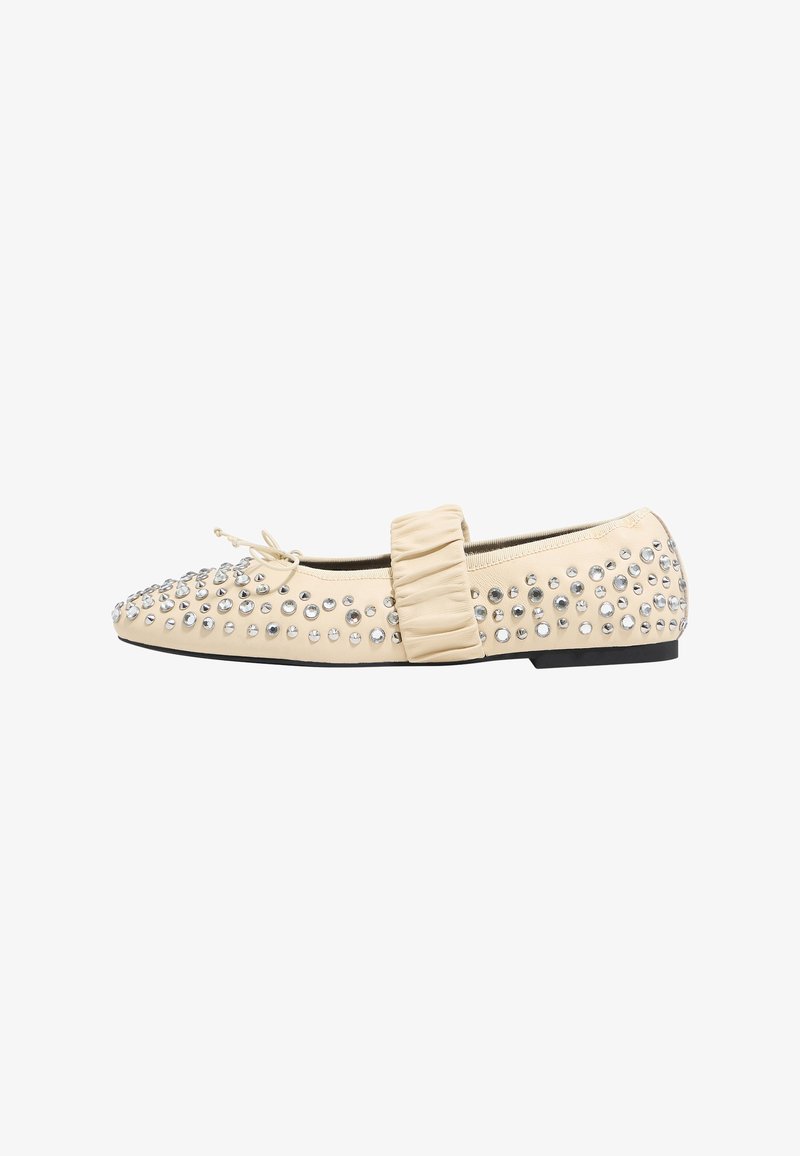Ballerine beige con decorazioni in strass, un cinturino arricciato sulla parte superiore del piede e suola nera piatta. Texture in pelle liscia.