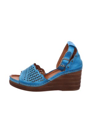 Blue leather wedge sandal with cut-out design, an ankle strap, and a textured brown wedge heel. Defined stitching accents the edges.