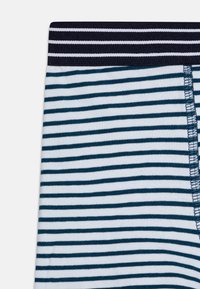 Stripete shorts i marineblå og hvit bomull med en myk linning. Side-søm detalj synlig på kanten.