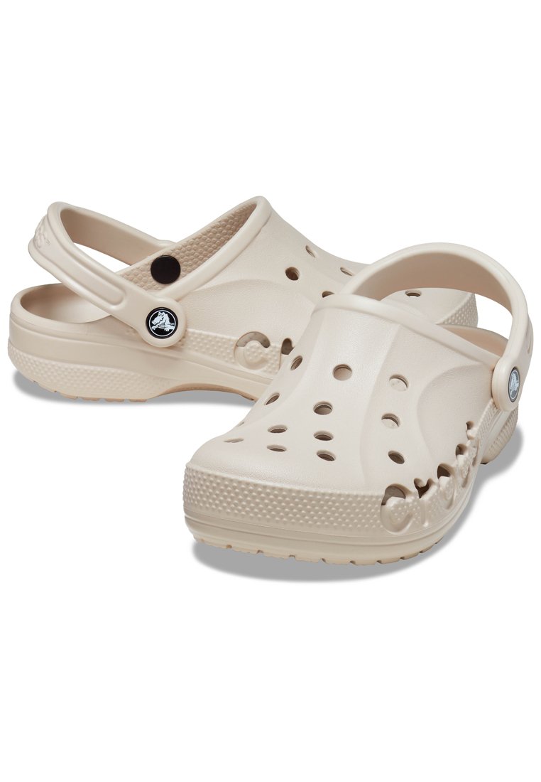 Beige rubber klompen met ventilatiegaten, achterband, logo-detail en gestructureerde zolen voor grip. Lichtgewicht en flexibele ontwerp.